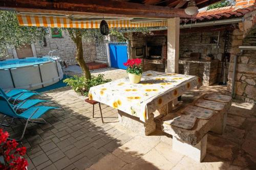 a table and chairs on a patio next to a pool at Tolles Ferienhaus in Peresiji mit Privatem Pool in Peresiji