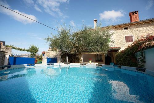 a large swimming pool in front of a house at Tolles Ferienhaus in Peresiji mit Privatem Pool in Peresiji