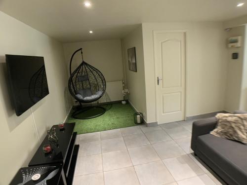 - un salon avec un canapé et une balançoire dans l'établissement Appartement cosy proche Roissy CDG Astérix DisneyLand Paris, à Goussainville