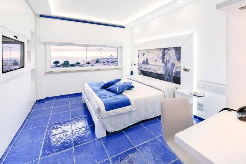 a bedroom with a king sized bed and blue tile floors at La Madegra Seasuite in Salerno