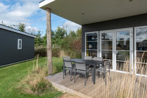a deck with a table and chairs on a house at Kompas Camping Nieuwpoort in Nieuwpoort