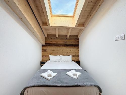 - une chambre avec un lit et 2 serviettes dans l'établissement Le Seraya - 5 pers- pistes à proximité, aux Gets