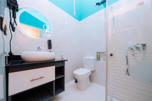 a bathroom with a sink and a toilet and a mirror at Rio Minho Oasis in Dambani
