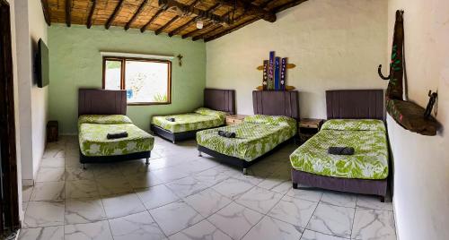 a room with three beds and a window at Hotel Monteverde Sutatausa in Sutatausa