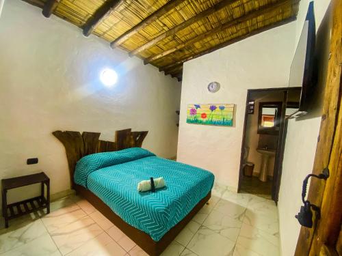 a bedroom with a blue bed in a room at Hotel Monteverde Sutatausa in Sutatausa