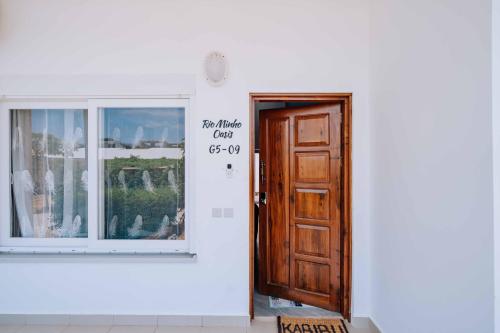 a white building with a wooden door with a sign on it at Rio Minho Oasis in Dambani