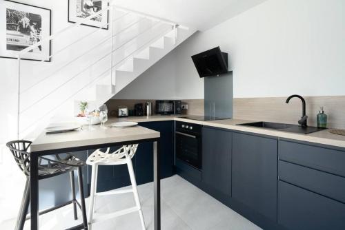 une cuisine avec des armoires bleues, un évier et une table dans l'établissement Le nid urbain - Station Muse, à Villeurbanne