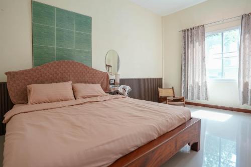 Postel nebo postele na pokoji v ubytování บ้านอัคคนี-Baan AUCKANEE