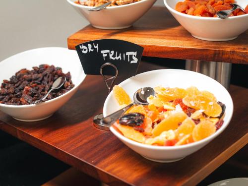 a buffet of bowls of fruit and nuts on a table at EA Hotel Rokoko in Prague