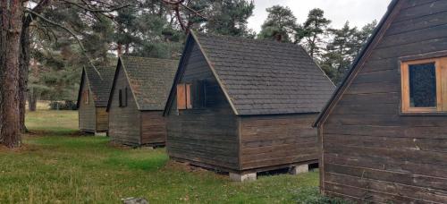 a row of wooden houses in a field at Albergue de Condemios de Arriba - Aventurarte in Condemios de Arriba