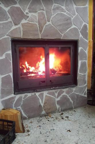 a stone fireplace with a fire in it at Albergue de Condemios de Arriba - Aventurarte in Condemios de Arriba