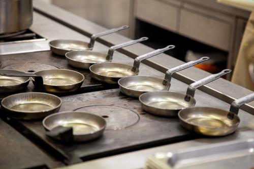 a group of metal pans on a stove in a kitchen at Romantik Hotel zur Sonne in Badenweiler