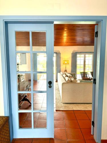a door leading to a living room with a couch at Comporta - Wood & Blue in Comporta