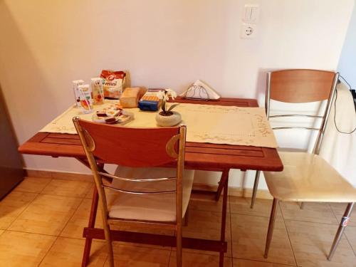 a wooden table with two chairs and a table with food on it at Emis House Krioneri in Kryonéri
