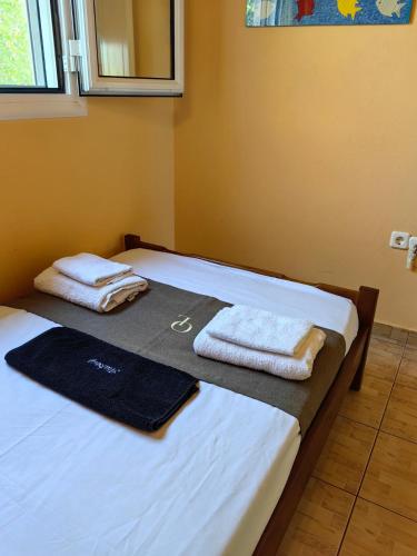 two beds in a room with towels on them at Emis House Krioneri in Kryonéri
