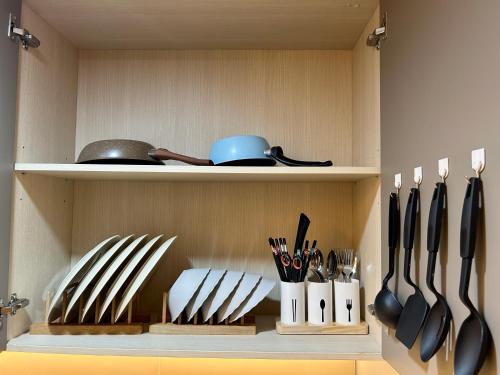 a cabinet with knives and utensils in it at Gold Coast Apartment PIK Luxury Sea View by stay with E in Jakarta