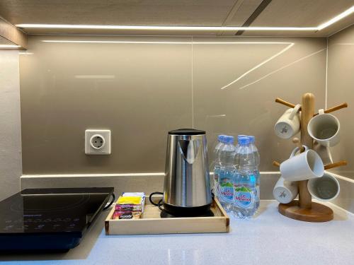 a kitchen counter with a coffee maker and bottles of water at Gold Coast Apartment PIK Luxury Sea View by stay with E in Jakarta