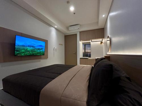 a bedroom with a large bed and a flat screen tv at Gold Coast Apartment PIK Luxury Sea View by stay with E in Jakarta