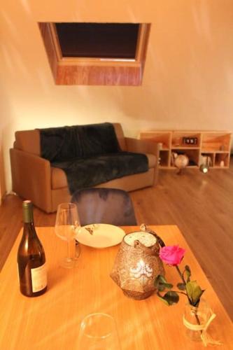 - un salon avec une table, des verres à vin et un canapé dans l'établissement Studio cosy en centre-ville, à Beauvais