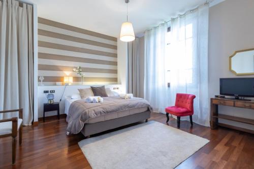 a bedroom with a bed and a red chair at Villa Lia - Apartment in Villa with private garden and Pool in Florence