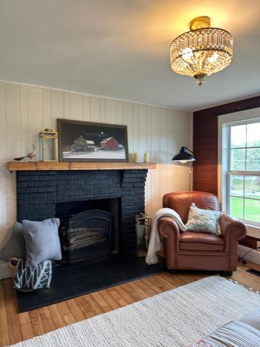 a living room with a fireplace and a chair at Cottage on the Hill Knoxville in Knoxville