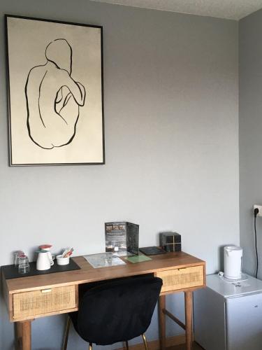 a desk in a room with a picture on the wall at Hôtel Des Argousiers in Ambleteuse