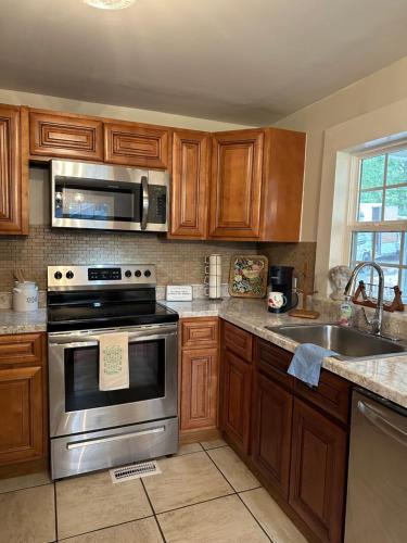 a kitchen with wooden cabinets and stainless steel appliances at Cottage on the Hill Knoxville in Knoxville
