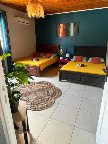 two beds in a room with a room with at Kaz à Naja in Saint-Louis