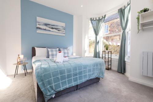 a blue bedroom with a bed and a window at Cardiff City Centre apartment Private Parking in Cardiff