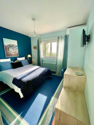 une chambre bleue avec un lit et une fenêtre dans l'établissement Villa Daphné, à Spéracèdes