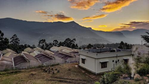 a group of domes with mountains in the background at Home stay in Kanthalloor
