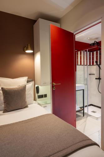 a bedroom with a red door and a bed at Hôtel Brady in Paris