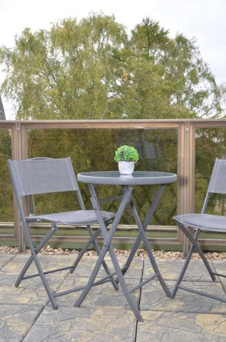 a table and two chairs and a potted plant on a patio at Hotel Neptuns Ankerplatz in Cuxhaven