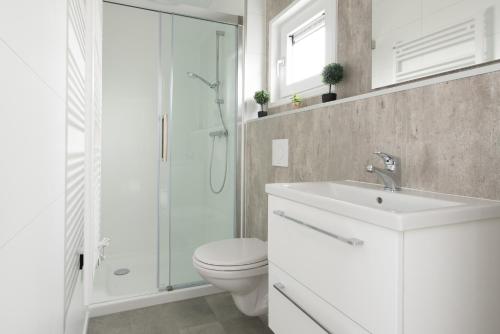 a bathroom with a toilet and a sink and a shower at Kompas Camping Nieuwpoort in Nieuwpoort