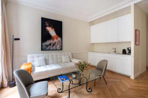 un salon avec un canapé blanc et une table dans l'établissement Elegant and tranquil 1 bed Parasian gem, à Paris
