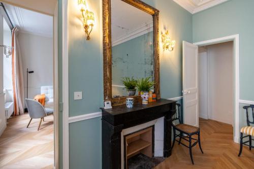 un salon avec une cheminée et un miroir dans l'établissement Elegant and tranquil 1 bed Parasian gem, à Paris