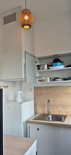 une cuisine avec des armoires blanches et un évier dans l'établissement T3 09 Calme et Agréable Parking, à Roubaix