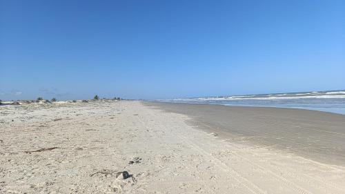 an empty beach with footprints in the sand at Casa lagoa dos tambaquis in Estância