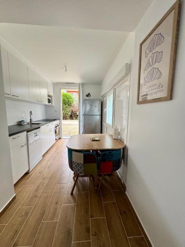 - une cuisine avec une table au milieu d'une pièce dans l'établissement Appartement avec jardin, à Gagny