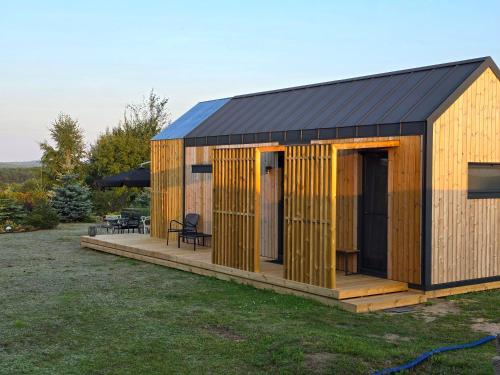 a wooden shed with a deck in a yard at Happy Jura in Biskupice