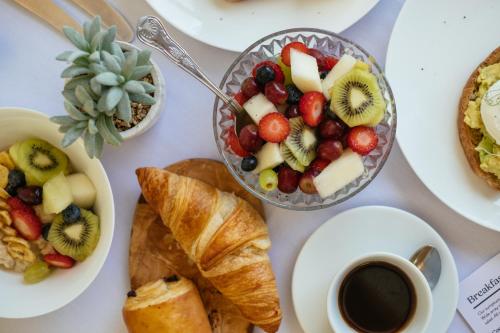 a table topped with plates of food and cups of coffee at Tŷ Afon - River House in Beddgelert