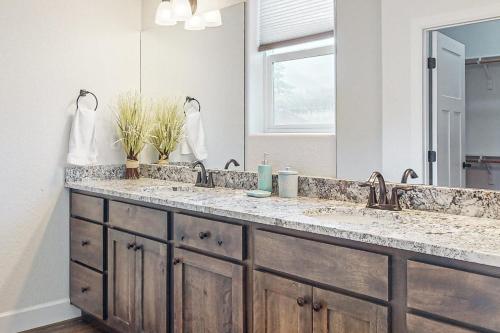 une salle de bain avec deux lavabos et un grand miroir dans l'établissement Under the Rye Sky, à Colorado City
