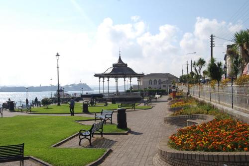 a park with benches and a gazebo next to the water at Castlemartyr Holiday Lodges No 20 2 Bed by Trident Holiday Homes in Castlemartyr