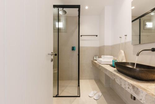 a bathroom with a sink and a glass shower at ANEMOLETHE in Kimolos