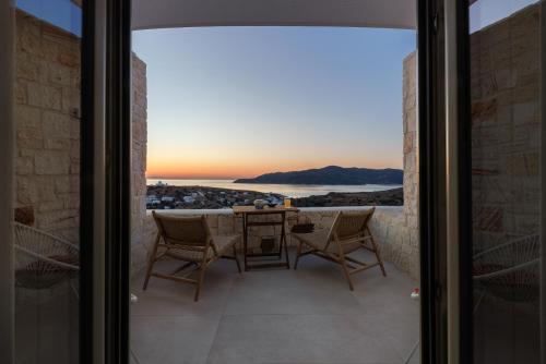 a view from the balcony of a house with a table and chairs at ANEMOLETHE in Kimolos