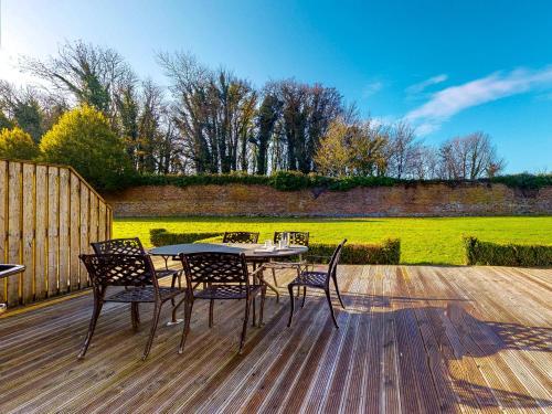 a patio with a table and chairs on a wooden deck at Castlemartyr Holiday Lodges No 20 2 Bed by Trident Holiday Homes in Castlemartyr