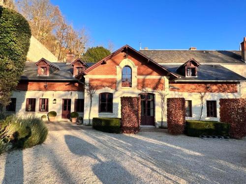 une vieille maison avec une allée en face de celle-ci dans l'établissement Manoir des Basses Rivières, à Rochecorbon