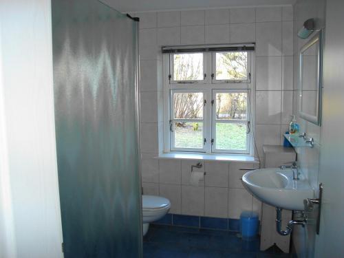 ヴィークにあるFerienwohnung Sierkeのバスルーム(洗面台、トイレ付)、窓が備わります。