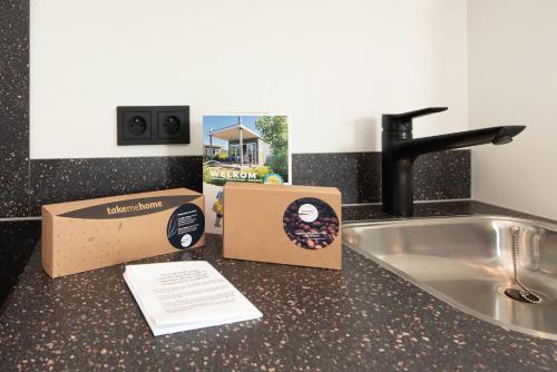a box of donuts on a counter next to a sink at Kompas Camping Nieuwpoort in Nieuwpoort