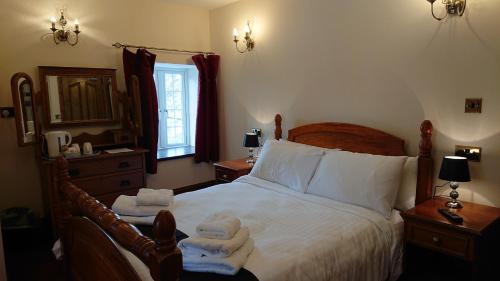a bedroom with a bed with towels on it at Great Trethew Hotel - Self Catering Lodges - Bar & Restaurant in Liskeard